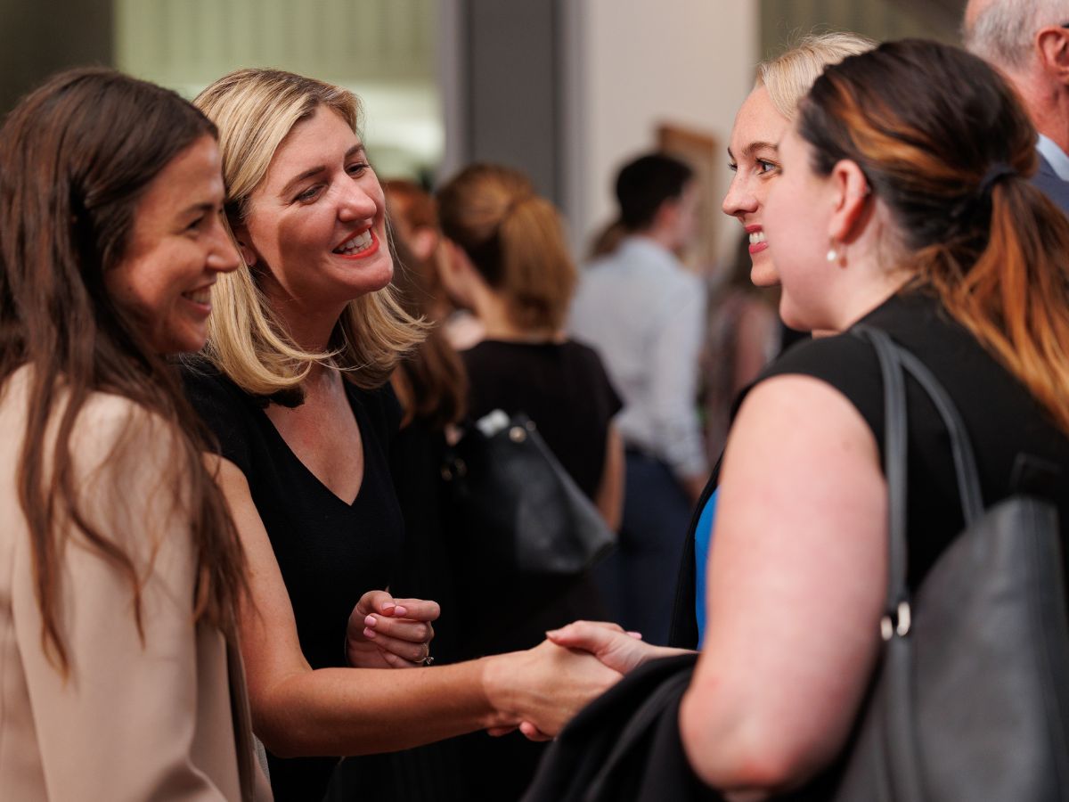 Photograph of young women chatting at networking event