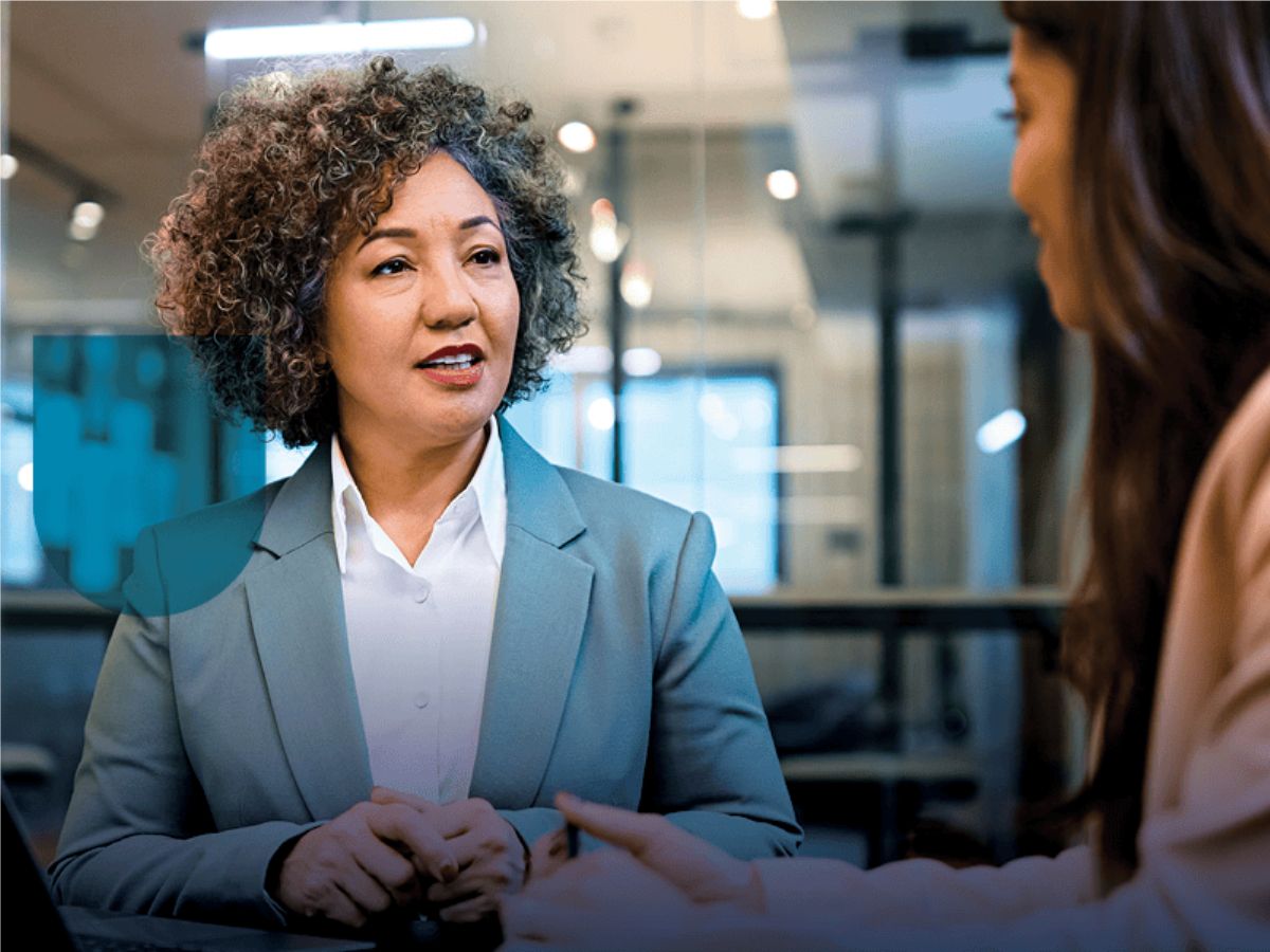 Woman in blazer talking to another woman